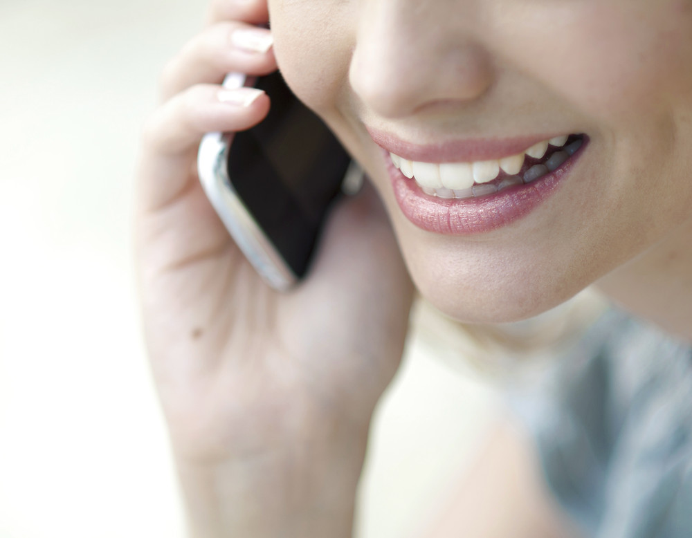 woman's mouth and on a cell phone